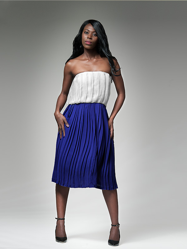 black female model in blue skirt and white top